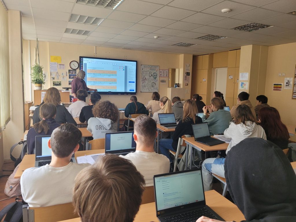 Skolēni klasē ar datoriem